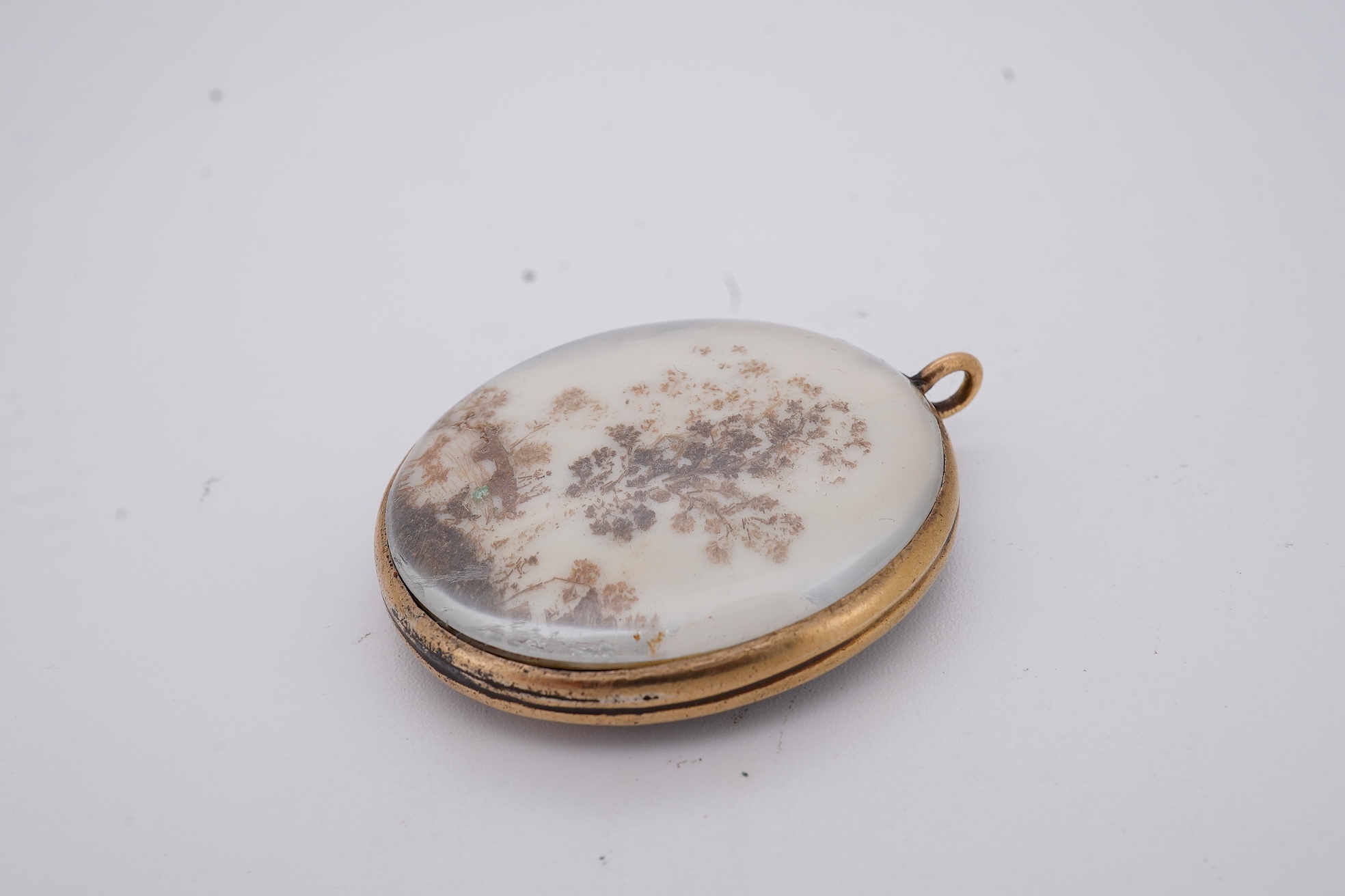 A 19th century gilt framed oval miniature watercolour portrait of a gentleman, on ivory, verso decorated with hair, depicting a landscape scene with a large tree, animals and a house, 36mm. CITES Submission reference, WU